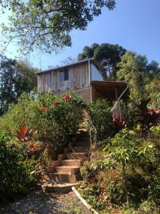 een klein houten huis met een trap daarheen bij Chalé Koch in Visconde De Maua
