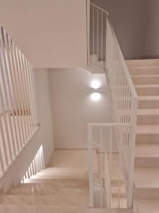 escalera blanca con barandillas blancas en una habitación en MYHome Lecce - SalentoSouthApulia, en Lecce