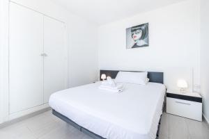 a white bedroom with a large white bed with white walls at Penthouse Bella Vista in Benidorm