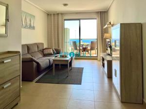 a living room with a couch and a table at MENTA Apto. con piscina a solo 200m de la playa in Calpe