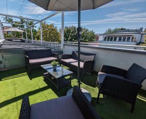 a patio with chairs and tables and an umbrella at Leipzig-Residenz Waldstraße am Zoo und Red Bull Arena , Rooftop Apartment mit 2 Dachterrassen in Leipzig
