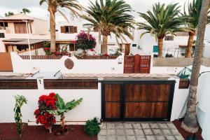 ein Haus mit einem Tor und Palmen in der Unterkunft La Palmera - Fabulosa Casa, LANZAROTE, Playa Honda in Playa Honda