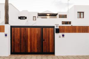 eine hölzerne Garagentür vor einem Haus in der Unterkunft La Palmera - Fabulosa Casa, LANZAROTE, Playa Honda in Playa Honda