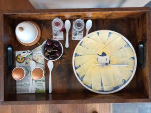 a wooden tray with a plate of food and spoons at Bed and Breakfast Hattem in Hattem