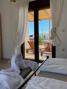 a bedroom with two beds and a view of a patio at Villa Filia in Gennadi