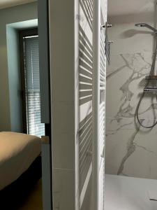a bedroom with a shower and a white wall at Umi in Ostend