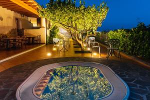 a hot tub in the middle of a patio at night at Hotel Residence La Villetta in Canneto