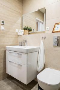 a bathroom with a white sink and a toilet at Apartmány Kubínska, Hillside in Dolný Kubín