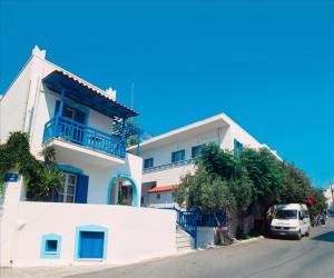 a white house with a van parked in front of it at Barbouni Hotel & Studios in Naxos Chora