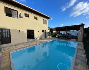 uma piscina em frente a uma casa em Buganville House Cabo Frio no Rio de Janeiro