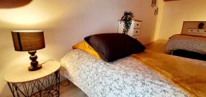 sypialnia z łóżkiem i stołem z lampką w obiekcie Les volets rouges du Moulin 