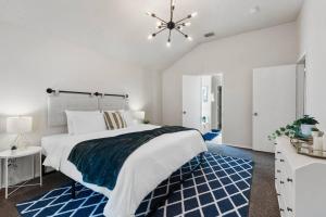 a bedroom with a large bed with a blue rug at *The Hideaway* NFLX/Arcade/Soak tub in Burleson