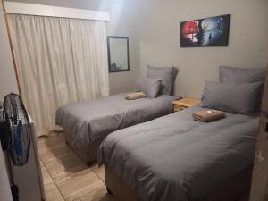 a bedroom with two beds and a window at BLUEBERRY BED AND BREAKFAST in Pietermaritzburg