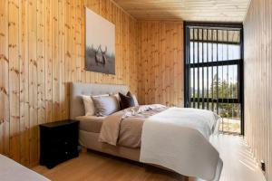 1 dormitorio con 1 cama en una pared de madera en Gaustablikk Hytte - MountainView, en Gaustablikk