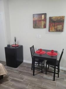 a black table and chairs with red plates on it at Sunshine in Tampa