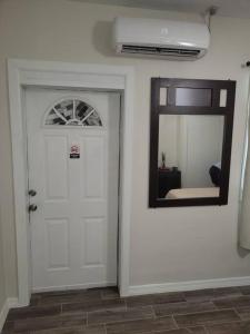 a hallway with a white door and a mirror at Sunshine in Tampa