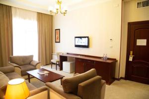 a living room with a couch and a desk and a tv at Capitol Hotel in Baku