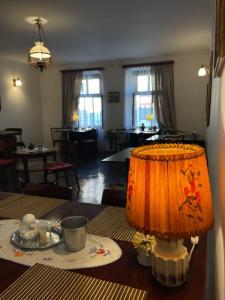 シビウにあるPensiunea Central Sibiuのリビングルームのテーブルに座るオレンジ色のランプ