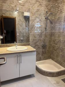 La salle de bains est pourvue d'un lavabo, d'une douche et d'une baignoire. dans l'établissement MARINA SKY, à Hurghada