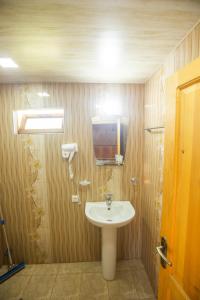łazienka z umywalką i telewizorem na ścianie w obiekcie Eco Cottage w Kutaisi