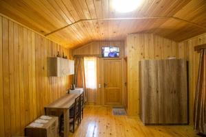 Habitación de madera con mesa y nevera en Eco Cottage, en Kutaisi