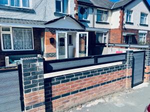 a brick retaining wall in front of a house at UNIQUE ROOMS! 4beds double bed in Farnworth