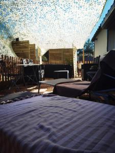 Część wypoczynkowa w obiekcie Résidence CAENEE, le dépaysement Naturiste en été avec l'atypique studio climatisé "vintage" en sous pente, sa "paillote" avec jacuzzi, entouré de verdure, planchagrill, transats, vélos gratuits, wifi 5G, Travel Proud LGBTQI, chiens admis