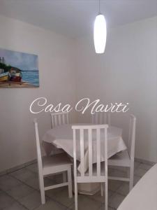 ボンビーニャスにあるCasa Naviti Rua Bem Te Vi 233 Bombinhas com piscinaの白いテーブルと絵画が飾られたテーブルと椅子 +21枚の写真