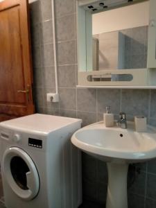 a bathroom with a washing machine next to a sink at Casa Margherita in Càbras
