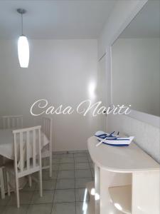 ボンビーニャスにあるCasa Naviti Rua Bem Te Vi 233 Bombinhas com piscinaのテーブルと椅子があり、「casa napita」と書かれた看板のあるキッチン