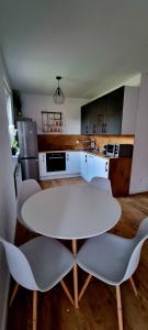 Biały stół i krzesła w kuchni w obiekcie Apartament Sołtysia Góra w Jeleniej Górze