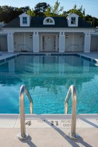 a swimming pool with a house in the background at Canoe Place Inn & Cottages in Hampton Bays