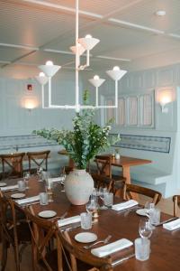 una sala da pranzo con tavolo e vaso di Canoe Place Inn & Cottages a Hampton Bays