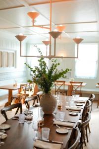 a dining room with a table with a vase on it at Canoe Place Inn & Cottages in Hampton Bays