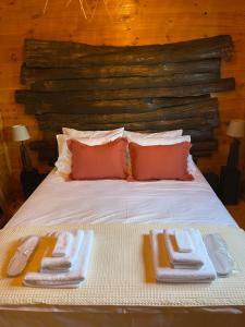 a bed with two towels and two slippers on it at Luxury Wooden Villas in Makrygialos