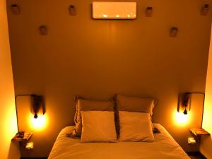 a bedroom with a bed with two lights on it at Au pied de la plage rdc in Sangatte