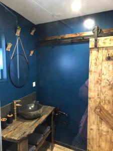 a bathroom with a blue wall and a sink at Au pied de la plage rdc in Sangatte