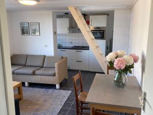 a living room with a table and a couch at Schrijvershuisje - sfeer & stilte Zeeuws Vlaanderen in Zaamslag