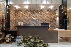 an office with a reception desk and a stone wall at Super OYO Collection O 91397 Tasqya Costel Syariah in Pekanbaru