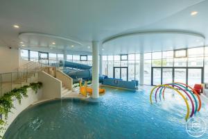 a indoor pool with a slide in a building at Polanki Aqua - Aquapark, Free Parking, Apartments M&M Kołobrzeg in Kołobrzeg