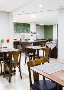 uma sala de jantar vazia com mesas e cadeiras em Hotel Pitol em Balneário Camboriú
