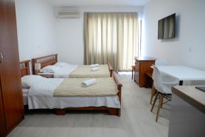 a hotel room with two beds and a desk at Villa Sandra Lagadin in Ohrid