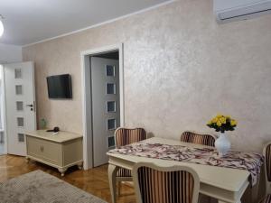 una sala da pranzo con tavolo, sedie e TV di Apartament QUIET a Galaţi