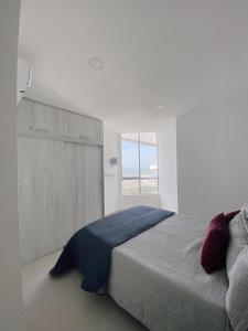 Un dormitorio con una cama grande y una ventana en lovely 2 bedroom Apartment with pool and gym, en Cartagena de Indias
