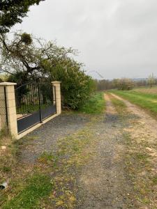 a gate on a dirt road next to a field at loge de la Besnardière in Mareuil-sur-Cher