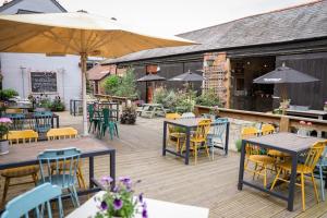 an outdoor patio with tables and chairs and umbrellas at The Black Swan Inn in Devizes