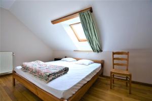 a bedroom with a bed with a window and a chair at Achouffe - MASSON in Houffalize