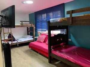 a bedroom with two bunk beds and a flat screen tv at XaviHostel in Bucaramanga