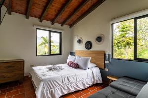 瓜塔佩Soy Local Guatape Campestre的带床、沙发和窗户的卧室