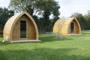 two yurt houses in a field with a table at Wolds Glamping in Pocklington